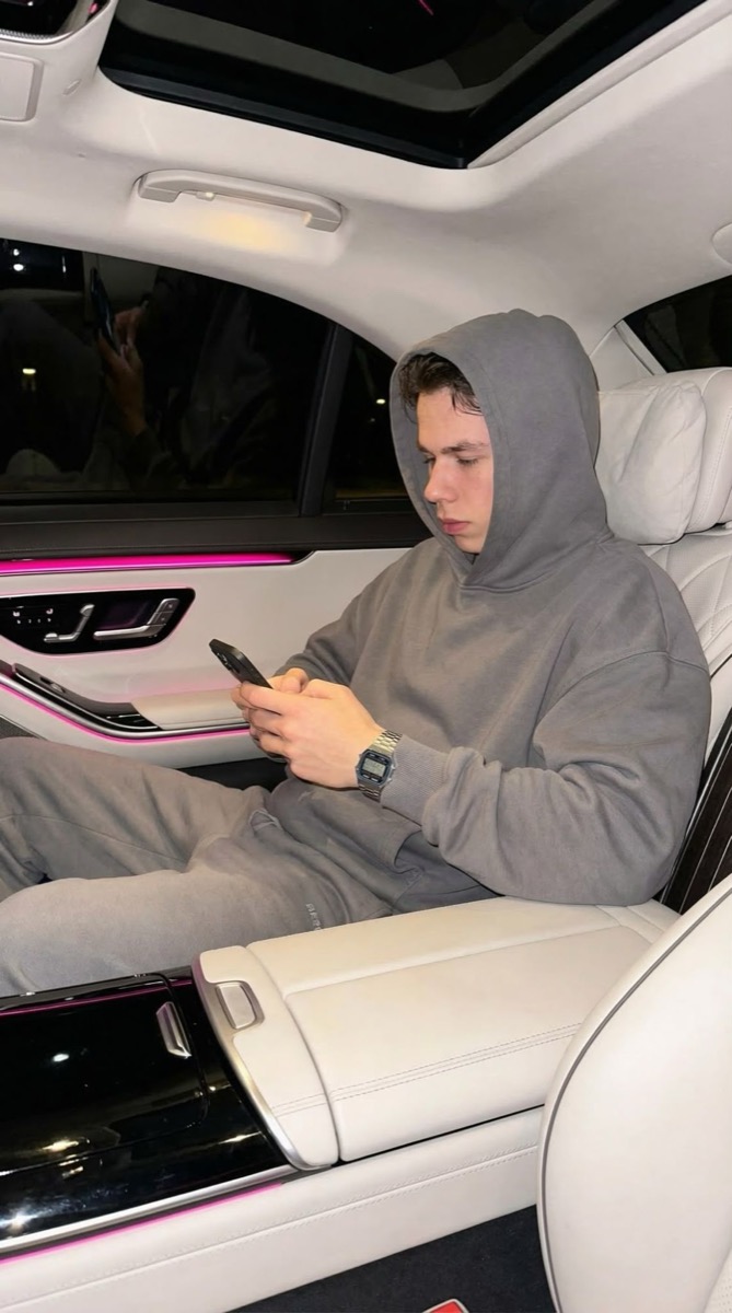 Felix im Fond eines Autos mit pinker Ambientebeleuchtung